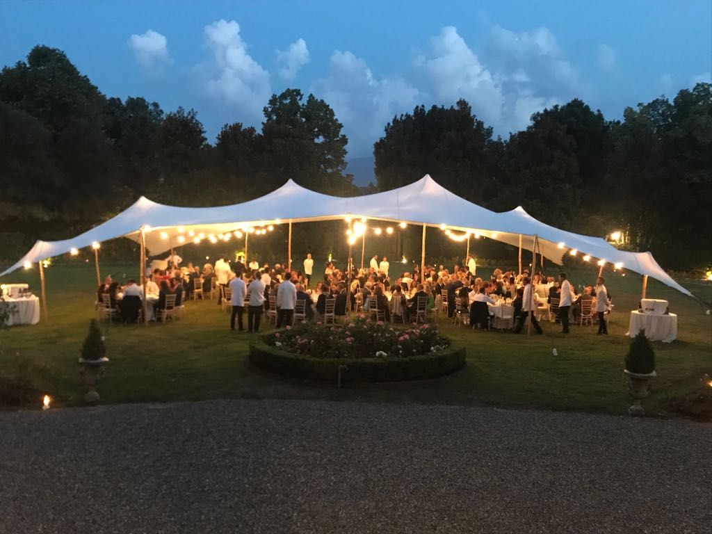 Open-sided stretch tent dressed with evening lighting and ready for a summer event in a garden setting, illustrative of the outdoor event spaces available at Weir Bank Estate, Bray-on-Thames, Berkshire.