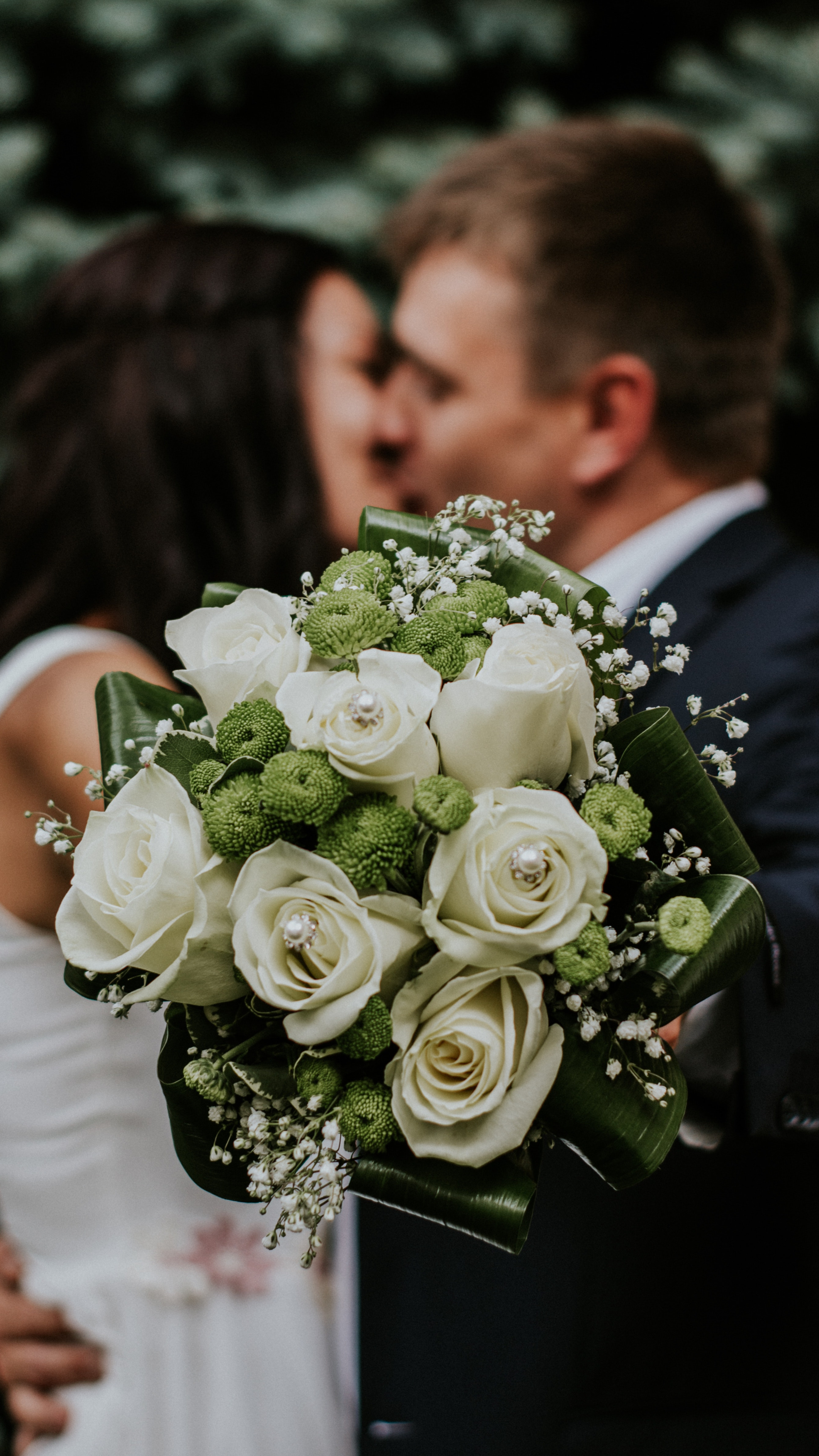 Bride and groom with a simple white bouquet in the grounds — illustrative of weddings at Weir Bank Estate, Bray-on-Thames, Berkshire.